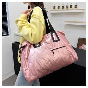 Detail of metallic pink travel bag showing side zipper pocket and wide black straps