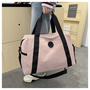 Detailed view of pink waterproof oxford travel bag with black straps and logo