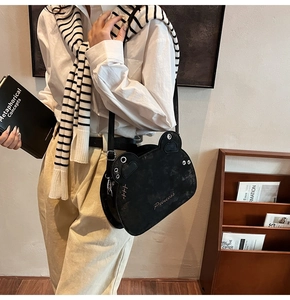 Detail of cute bear-shaped black crossbody bag with Princess gold lettering and stud accent