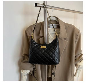 Détail du sac à main matelassé noir avec chaîne dorée et fermoir rotatif en métal