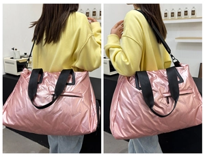 Detail of metallic pink quilted travel bag showing glossy texture and black shoulder strap
