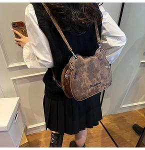 Close-up of a brown bear-shaped shoulder bag with Princess embroidery and matte leather
