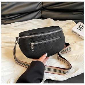 Detail of black lychee grain saddle bag featuring silver zippers and striped strap