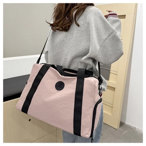 Pink travel bag detail showing side shoe compartment and black reinforced handles