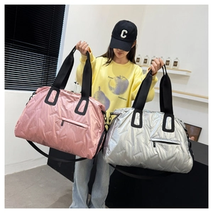 Detail of pink and silver quilted travel bags with metallic finish and wide straps