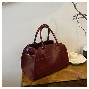 Detail of wine red leather tote with white contrast stitching and round top handles