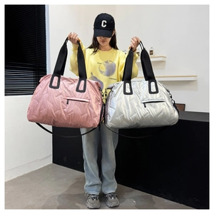 Quilted waterproof gym bag with metallic finish and wide shoulder strap detail