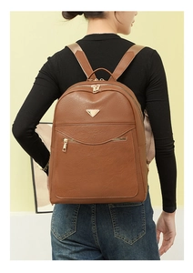 Detail of brown faux leather backpack with metallic zippers and adjustable straps