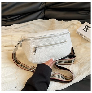 Close-up of white lychee texture leather saddle bag with striped woven shoulder strap