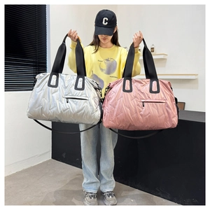 Detail of silver and pink quilted travel bags with metallic texture and shoulder straps