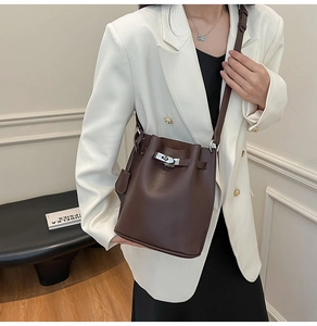Detail of dark brown lychee grain leather bucket bag with silver metal twist lock