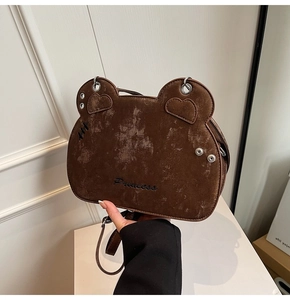 Detailed shot of brown bear-shaped shoulder bag with Princess embroidery and suede texture