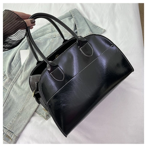 Detail of vintage black bowling tote bag featuring white contrast stitching and oil wax leather