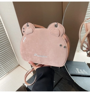 Detailed view of pink heart-eared crossbody bag with soft suede texture and Princess embroidery