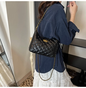 Détail du sac bandoulière en cuir noir matelassé avec chaîne dorée et fermoir