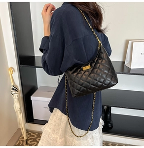 Détail du sac bandoulière matelassé noir avec chaîne dorée et fermoir pivotant chic