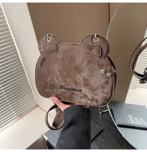 Detail of a brown bear-shaped crossbody bag with Princess embroidery and suede texture