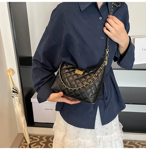 Détail du sac à bandoulière en cuir noir matelassé avec chaîne dorée et fermoir