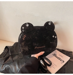 Close-up of black suede crossbody bag with Princess embroidery and cat ear details