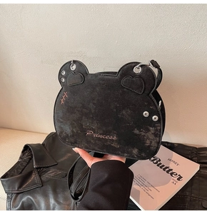 Close-up of black bear-shaped crossbody bag with pink Princess embroidery and metal studs