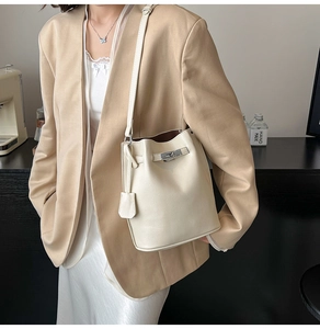 Detail of off-white bucket bag with litchi grain leather and silver twist lock closure