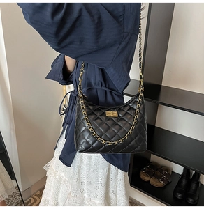 Vue détaillée du sac à bandoulière matelassé noir avec chaîne dorée et fermoir pivotant