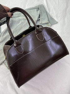 Classic dark brown glossy leather tote bag with white stitching and round handles