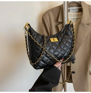 Détail du sac dumpling noir matelassé avec chaîne dorée et fermoir métallique
