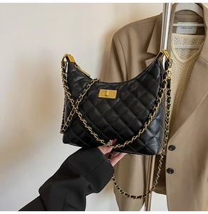 Détail d'un sac bandoulière matelassé noir avec chaîne dorée et fermoir pivotant carré