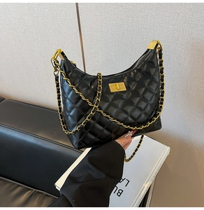 Gros plan sur un sac en cuir matelassé noir avec bandoulière chaîne dorée et fermoir