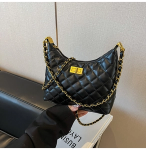 Gros plan du sac hobo matelassé noir avec bandoulière chaîne dorée et fermoir en métal