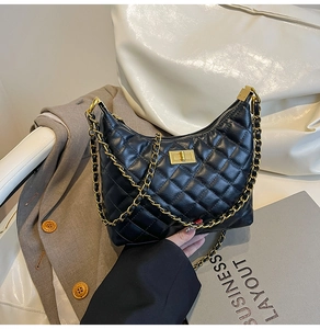 Détail du sac hobo en cuir noir matelassé avec bandoulière chaîne dorée et fermoir pivotant