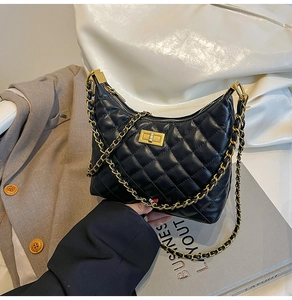 Détail du sac bandoulière matelassé noir avec chaîne dorée et fermoir métallique