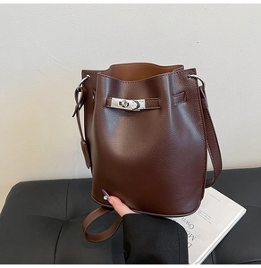 Detail of dark brown lychee leather bucket bag with silver metal swivel lock