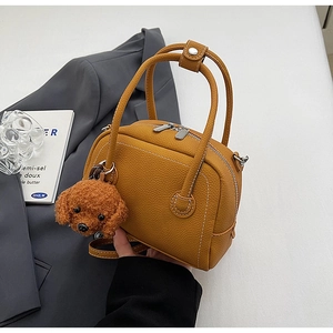 Détail du sac bowling en cuir grainé jaune avec un charmant porte-clés ours en peluche