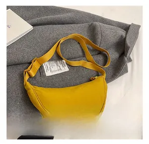 Macro detail of mustard yellow nylon crescent bag showing interior label and fabric texture