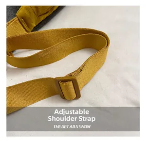 Detail of adjustable nylon shoulder strap and plastic buckle on casual dumpling bag