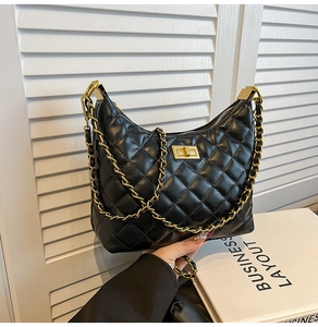 Détail d'un sac à bandoulière en cuir noir matelassé avec fermoir doré chic
