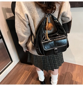 Vue arrière du mannequin portant un grand cabas noir verni avec un charmant ours en peluche