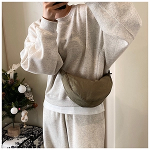 Olive green nylon crescent bag worn crossbody with casual home style outfit