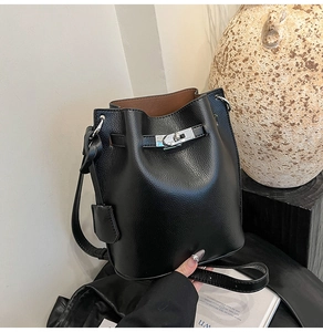 Close-up of black litchi grain leather bucket bag with silver metal twist lock detail
