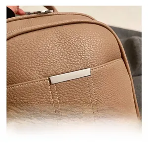 Detail of brown pebble leather backpack showing silver buckle and white stitching