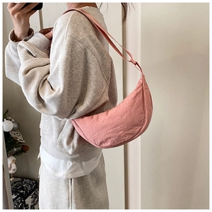 Mirror selfie showing a pink nylon hobo bag styled as a casual crossbody shoulder bag