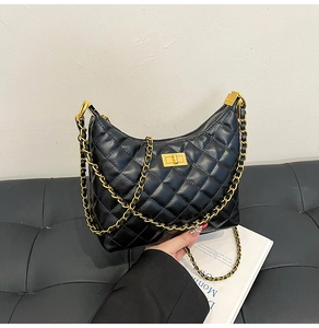 Détail du sac hobo en cuir noir matelassé avec chaîne dorée et fermoir rotatif carré
