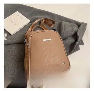 Close-up of textured beige leather backpack with vertical stitching and silver zippers