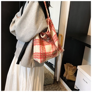 Vista lateral de un bolso tote de felpa a cuadros rojos y blancos con cordones de cuero