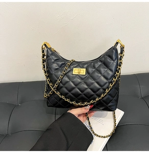 Détail de la texture en cuir noir matelassé et du fermoir doré du sac à bandoulière