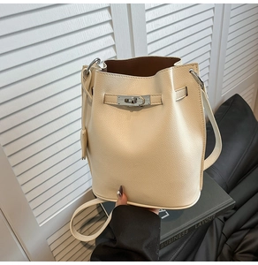 Detail of off-white bucket bag featuring lychee grain leather and silver metal lock