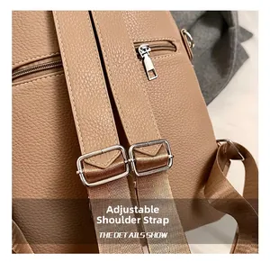 Detail of adjustable nylon straps and khaki pebble leather texture on backpack