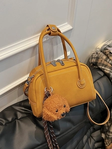 Sac bowling en cuir jaune gingembre avec charme chien sur siège en cuir noir